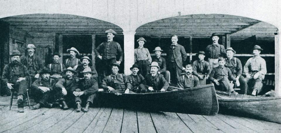 Early black and white photo of guides posing with canoes at Paul Smith's Hotel.