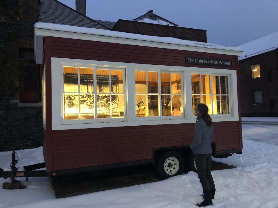 The mobile "Cure Porch on Wheels" illuminated in the evening winter light.