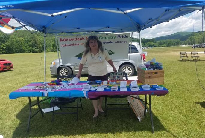 Kelly Metzgar poses at an informational tent for the Adirondack North Country Gender Alliance.