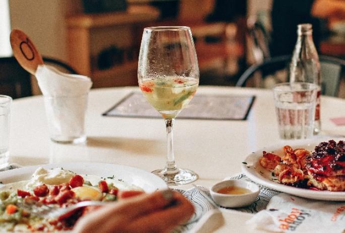 A glass of wine paired with a pasta dish at a fine dining establishment.