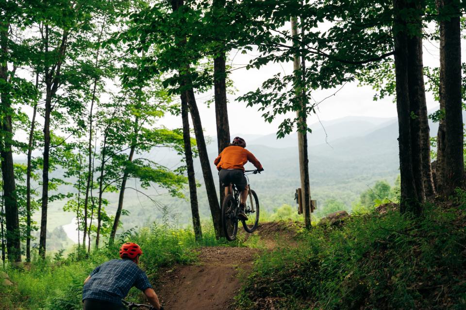 A mountain biker goes over a small jump