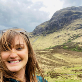 A selfie of a woman with a scenic background.