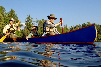 Three people canoeing on a lake