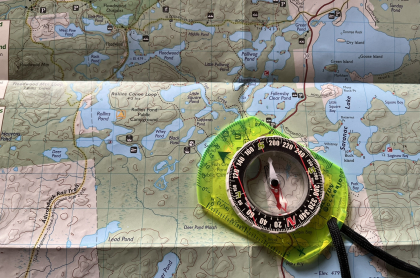 A map with a compass laying on top.