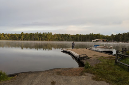 Sturdy boat launch onto a picturesque lake as smooth as glass and ringed with pines