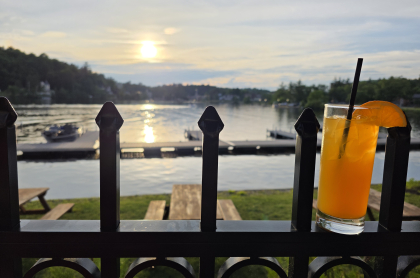A sunset view of the lake from the patio with a freshly poured beverage