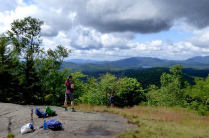 A hiker stands on partially open summit
