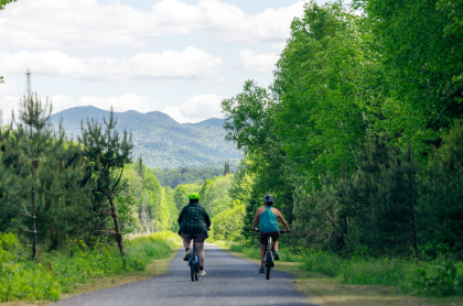 Two people cycle on a rail trail