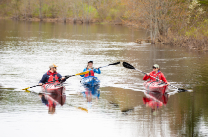 Three paddlers going down a river