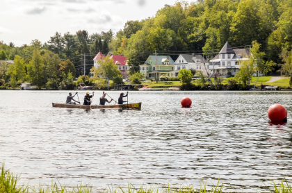 A team of four paddle a canoe down a river