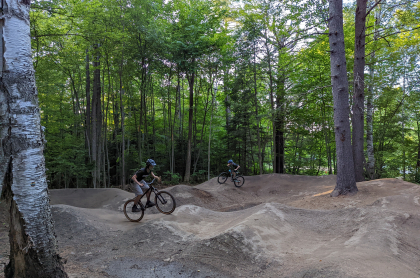 A kid jumps a dirt ramp on his bike