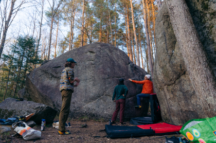 A group of bouderers working on a problem