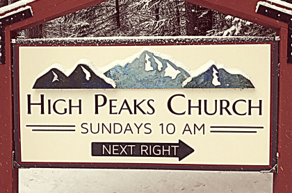 A sign for the entry to High Peaks Church blanketed in light snow