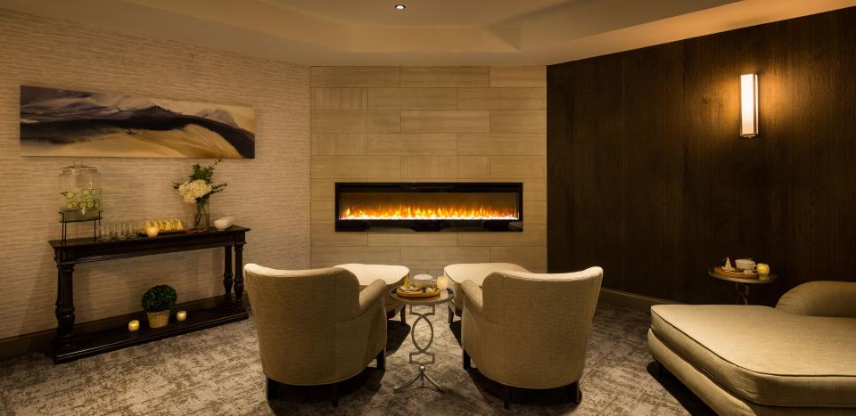 View of two chairs facing a floating gas fireplace at Ampersand Salon and Spa at Hotel Saranac