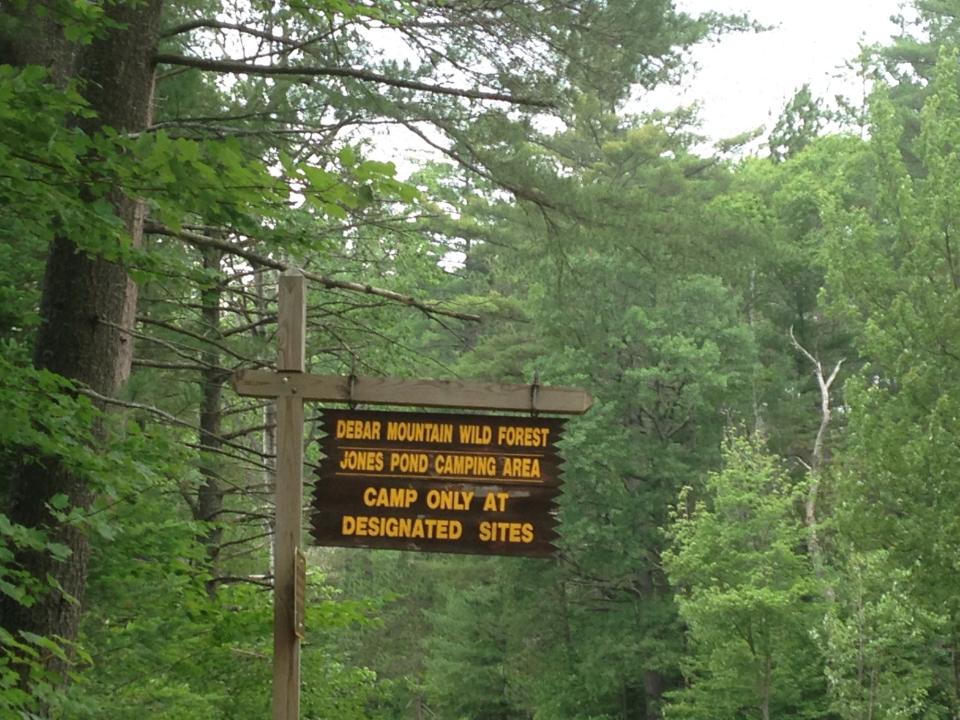 A brown and yellow sign of Jones Pond camping area