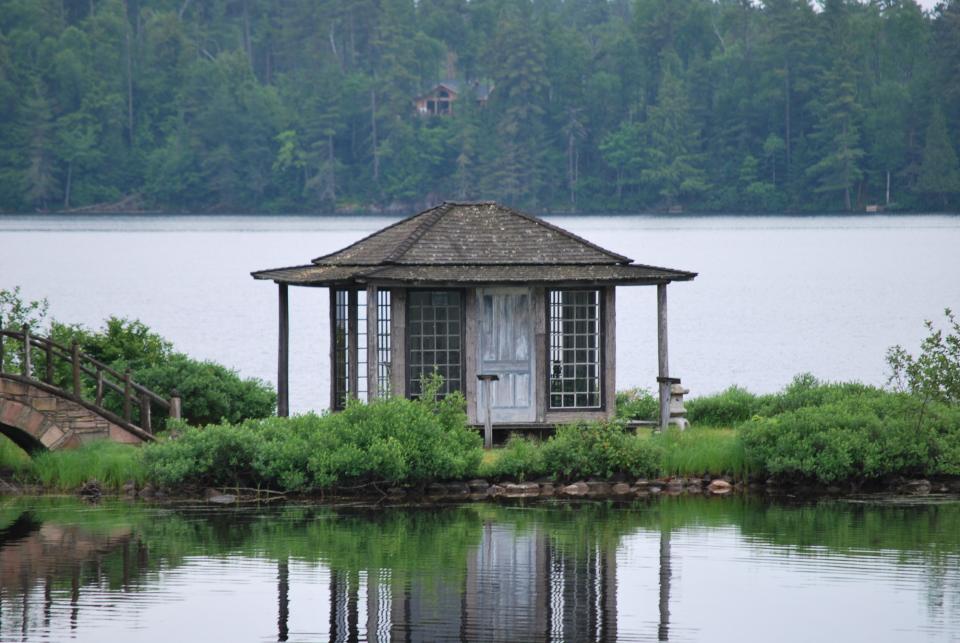 An old tea house on a narrow strip of land in a pond