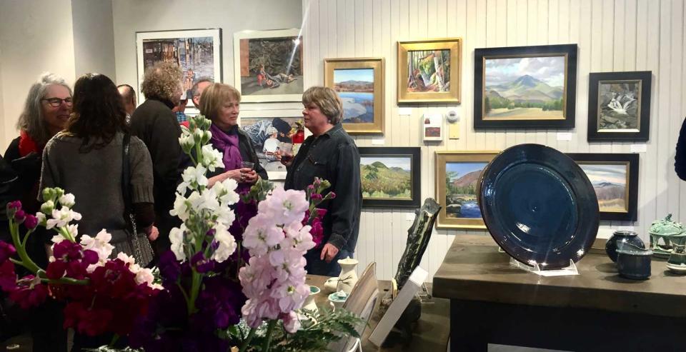 People at a gallery viewing works completed by Adirondack painters