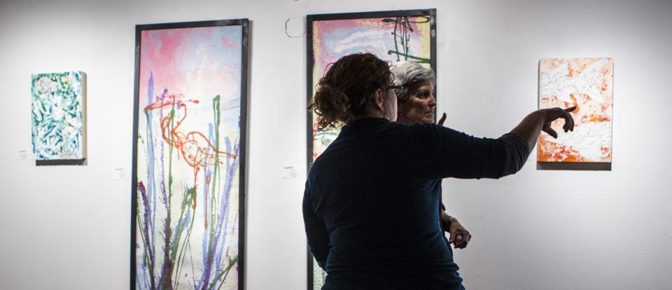 Two woman checking out art at an exhibit.