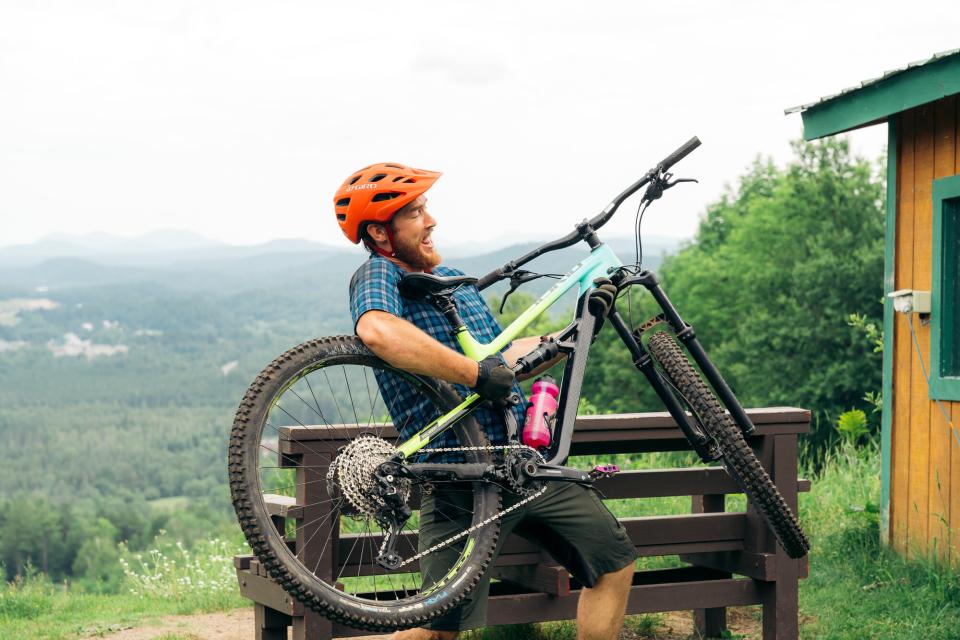 A mountain biker plays the guitar, but instead of a guitar, he uses his bike