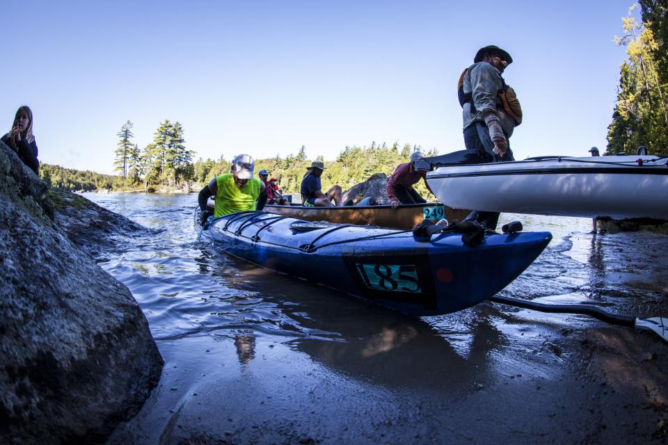 Three groups of participants leaving the water in the water in the 90-Miler Adirondack Canoe Classic
