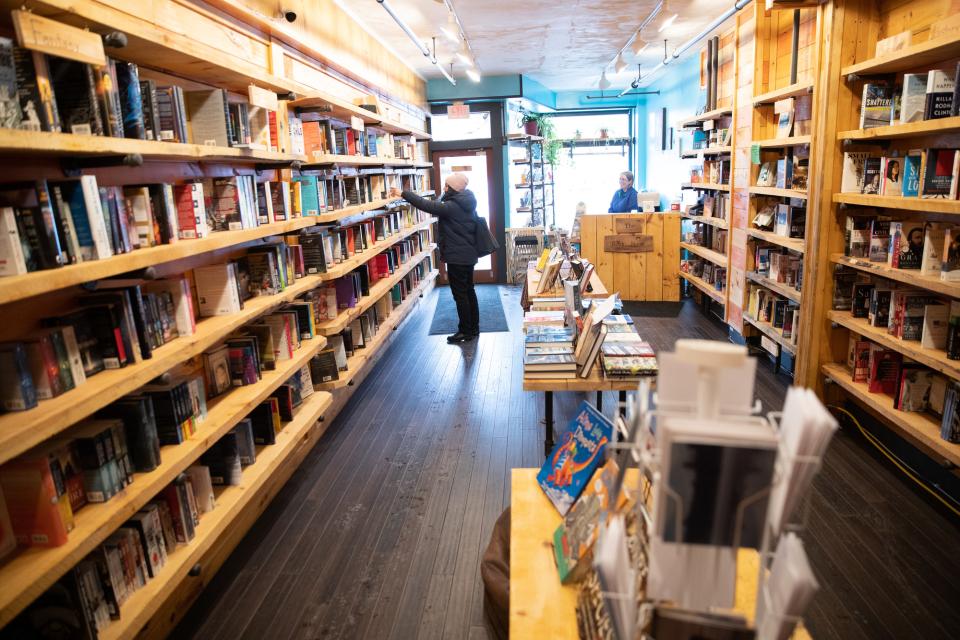 A person browses the shelves at a small bookstore.