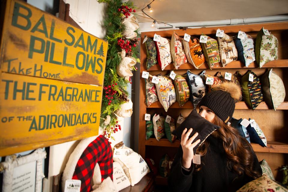 A shopper smells a balsam pillow in an Adirondack-themed display.