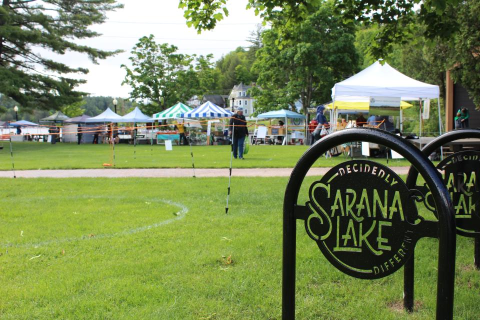 The Saranac Lake "Decidedly Different" sign stands in front of the farmers market
