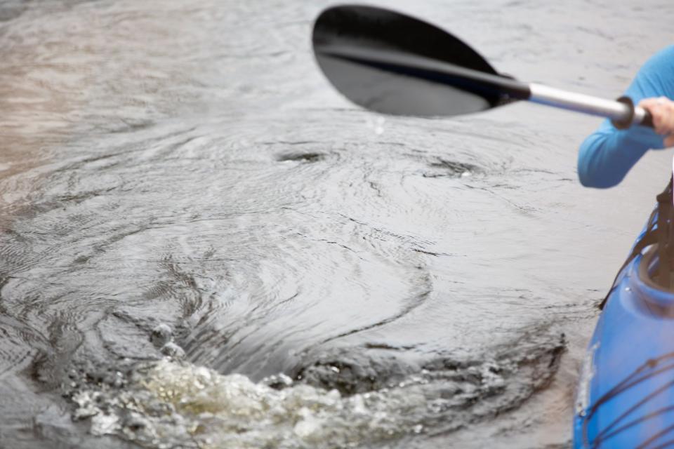 Water swirling from a kayaker's oar having been pushed through the water