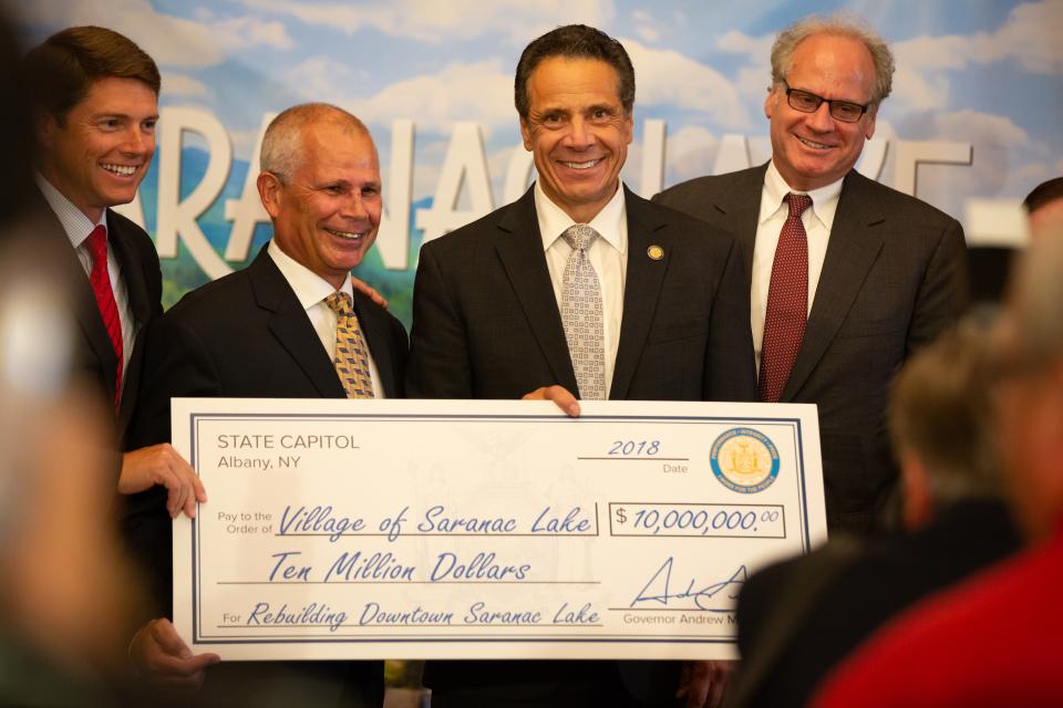 Saranac Lake Mayor Clyde Rabideau is joined by Assemblyman Billy Jones and Gov. Cuomo holding the giant $10 million dollar grant award check.