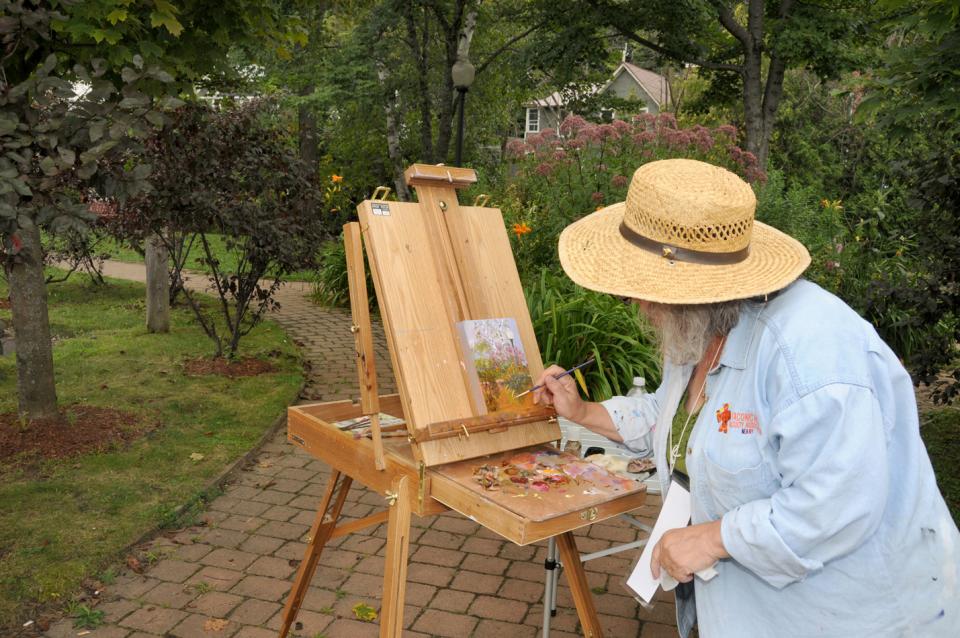 a woman paints the trees in the park