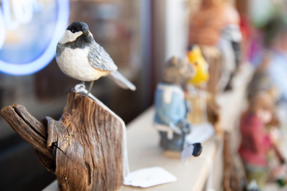A wooden Black-capped Chickadee on display at an art event.