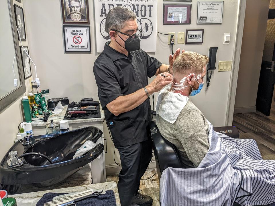 A man gets his hair cut at a barber shop
