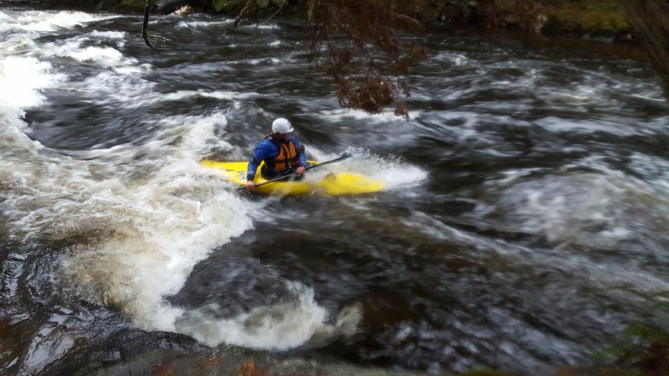 Jim Sausville paddles his yellow kayak along a river.