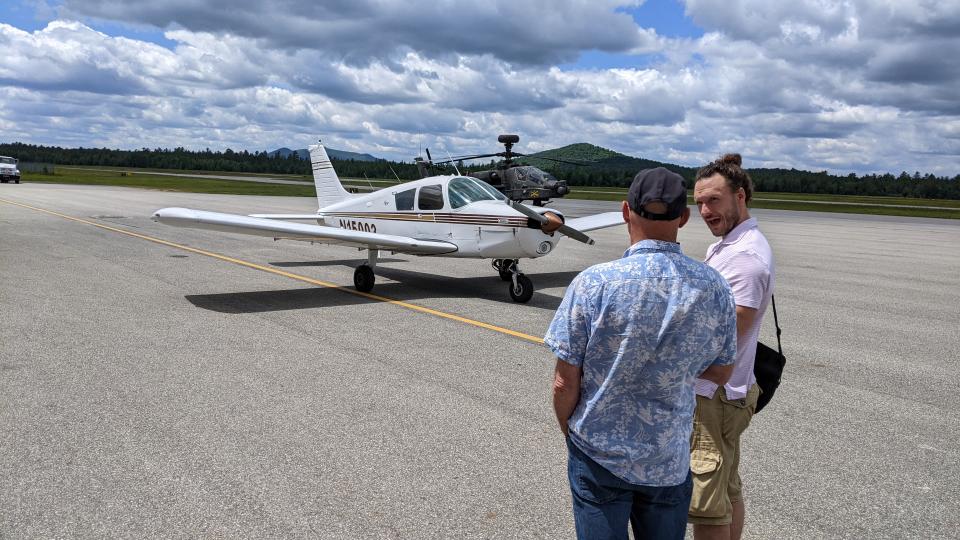 Two men in front of a Piper Cherokee