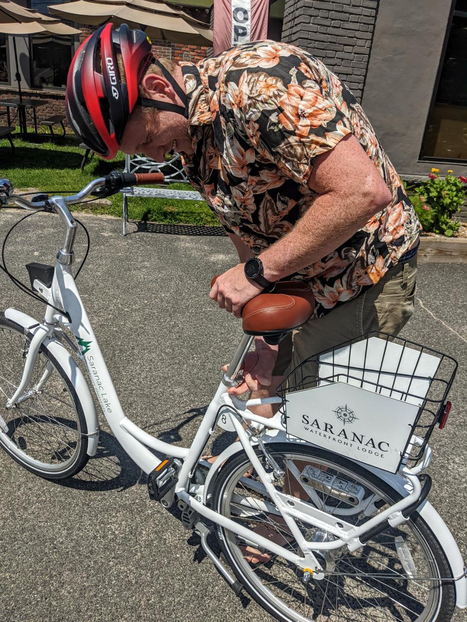 A man adjusts his saddle height on a bike.