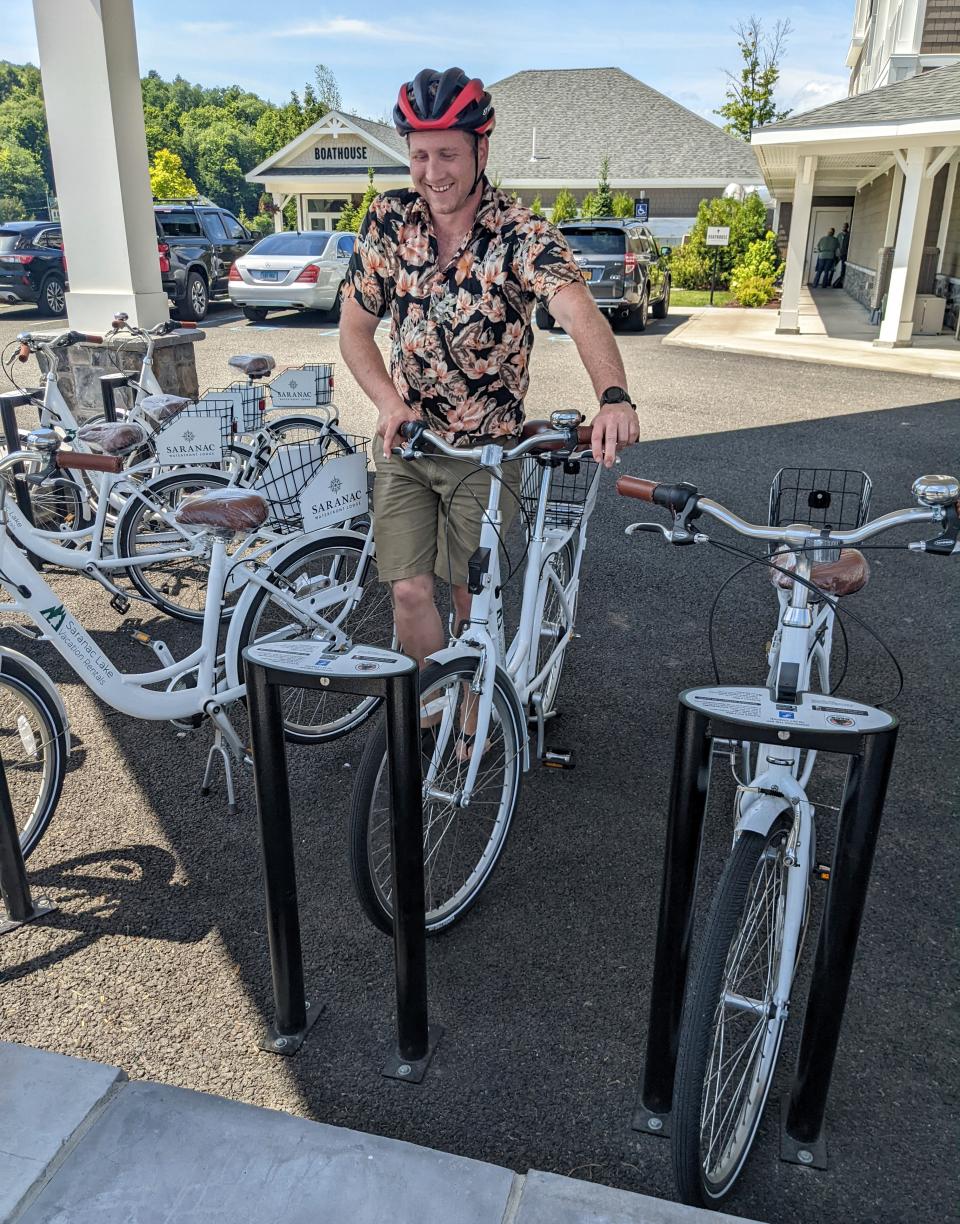 A man returns his bike to a bike rack.