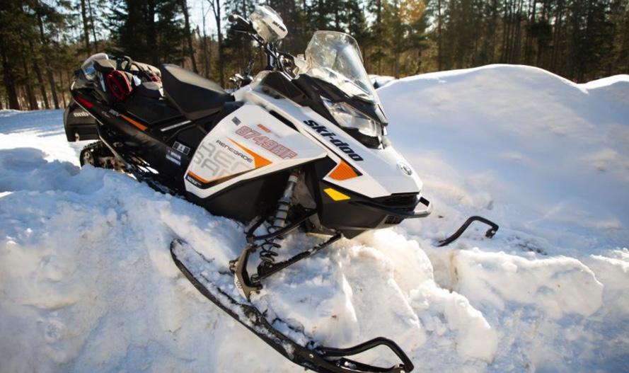 Close-up of a snowmobile on a deep snowbank.