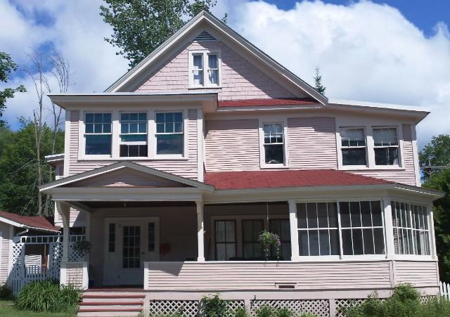 A pink home featuring several cure porches that was previously used as one of Saranac Lake's cure cottages