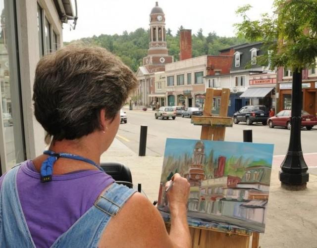 An artist paints on main street during the Plein Air Festival.
