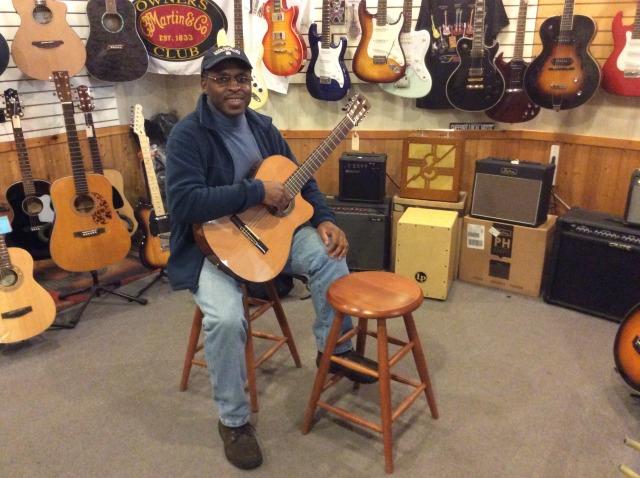 A guitar player tries out a new (or gently used) instrument in Ampersound's guitar room.