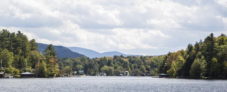 A photograph of the village of Saranac Lake from the perspective of a 'Round the Mountain Canoe Race participant