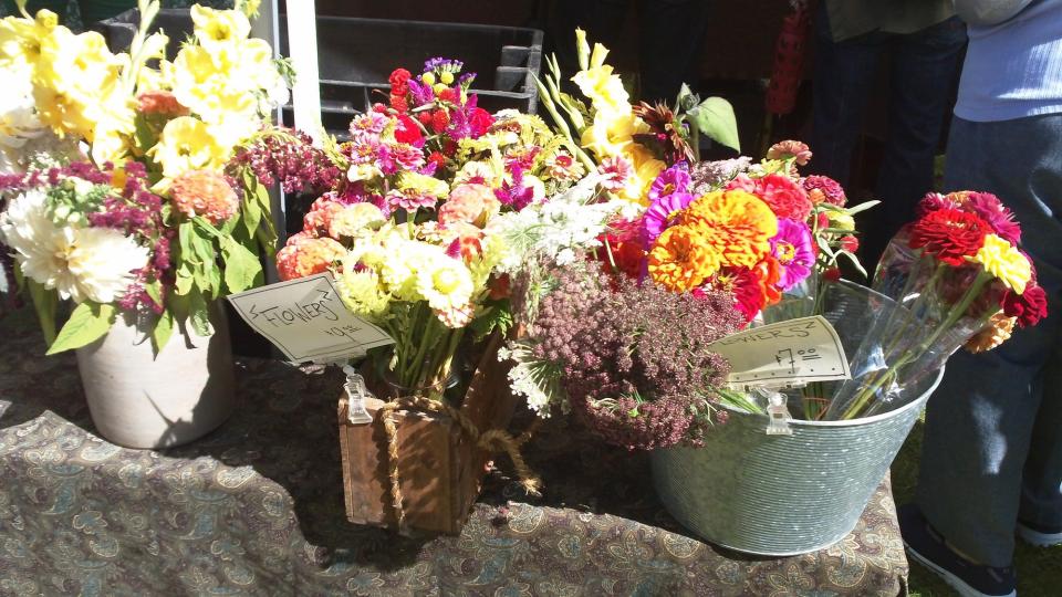An array of cut flowers in metal buckets