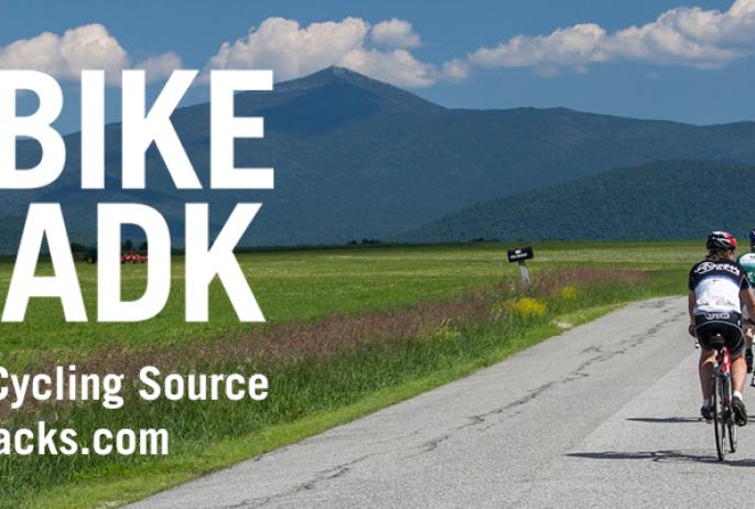 Link to BikeAdirondacks.com with two cyclists on the road.