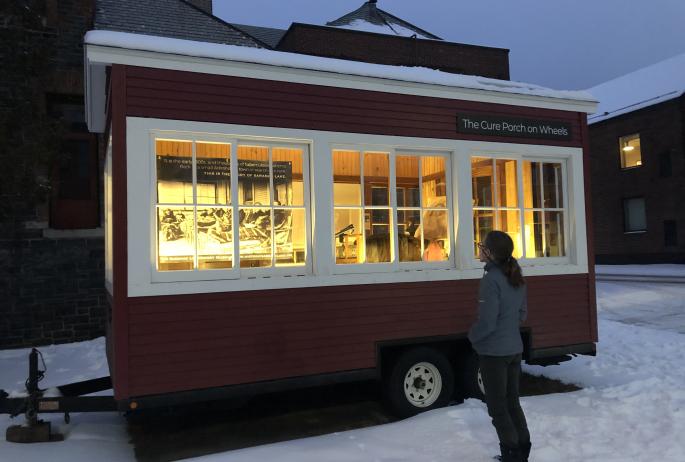 The mobile "Cure Porch on Wheels" illuminated in the evening winter light.