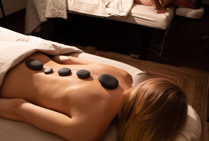 A woman receiving a hot stone massage.