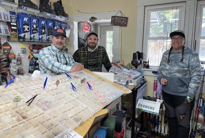 Three fishing guides inside a fly shop.