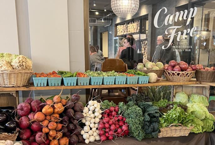 A table of fresh produce on display indoors, outside Campfire Grill and Bar.