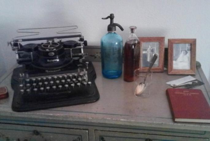 A typewriter and photos sit on a desk