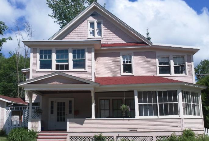 A pink home featuring several cure porches that was previously used as one of Saranac Lake's cure cottages