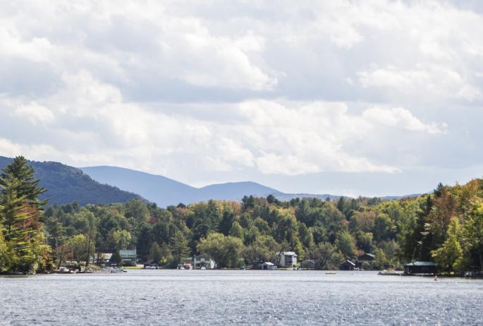 A photograph of the village of Saranac Lake from the perspective of a 'Round the Mountain Canoe Race participant